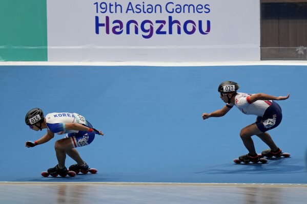 South Korea's Cheolwon Jung, left, and Taiwan's Yu-Lin Huang compete in the men's Speed Skating 3000 meter Relay Race G1 final at 19th Asian Games in Hangzhou, China, Monday, Oct. 2, 2023. (AP Photo/Aijaz Rahi)