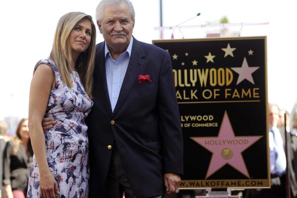 FILE - Actress Jennifer Aniston, left, poses with her father, actor John Aniston, after she received a star on the Hollywood Walk of Fame in Los Angeles on Feb. 23, 2012. John Aniston, the Emmy-winning star of the daytime soap opera “Days of Our Lives” and father of Jennifer Aniston, has died at age 89.  The actor’s daughter posted a tribute to him Monday morning on Instagram, announcing that he had died Friday, Nov. 11. (AP Photo/Chris Pizzello, File)