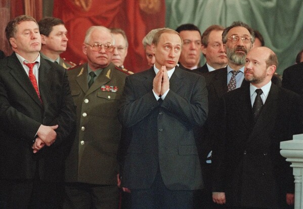 Vladimir Putin, center, attends a Christmas service in Christ the Savior Cathedral in Moscow, Jan. 8, 2000. (AP Photo/Misha Japaridze, File)