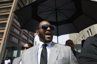 FILE - In this June 6, 2019, file photo, musician R. Kelly leaves the Leighton Criminal Court building in Chicago. Minnesota authorities charged singer R. Kelly on Monday, Aug. 5, 2019, with two counts of prostitution and solicitation involving a girl under 18 in 2001. (AP Photo/Amr Alfiky, File)