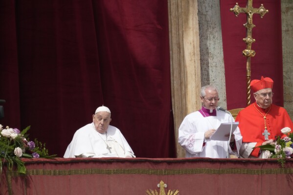 Pope Francis, left, appears on the central lodge of St. Peter's Basilica to bestow the Urbi et Orbi (Latin for to the city and to the world) blessing at the end of the Easter mass presided over by Cardinal Angelo Comastri in St. Peter's Square at the Vatican Sunday, April 20, 2025. (AP Photo/Gregorio Borgia)