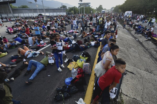 Migrants block the highway during their caravan through Huixtla, Mexico, Wednesday, Nov. 8, 2023. About 3,000 migrants, mostly from Central America, are protesting for the government to issue them temporary documents allowing them to continue north to the U.S. border. (AP Photo/Edgar Clemente)