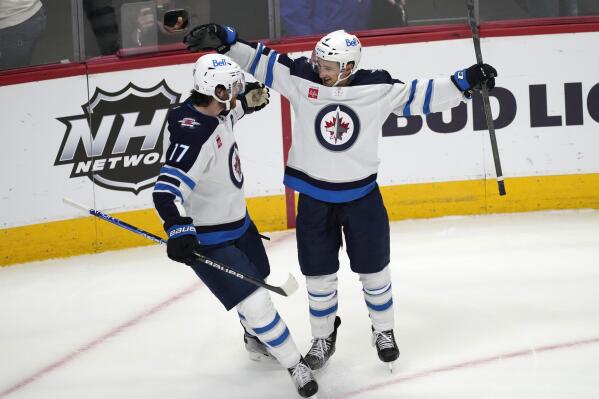 Winnipeg Jets center Adam Lowry, left, celebrates with defenseman Neal Pionk, who scored in overtime against the Colorado Avalanche during an NHL hockey game Wednesday, Oct. 19, 2022, in Denver. (AP Photo/David Zalubowski)