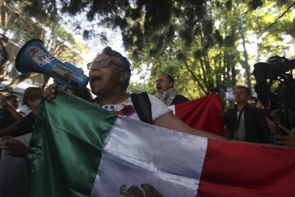 People protest outside the Ecuadorian embassy in Mexico City, Saturday, April 6, 2024. Mexico's government cut diplomatic ties with Ecuador after police stormed the Mexican embassy to arrest a former vice president of Ecuador.  (AP Photo/Ginnette Riquelme)