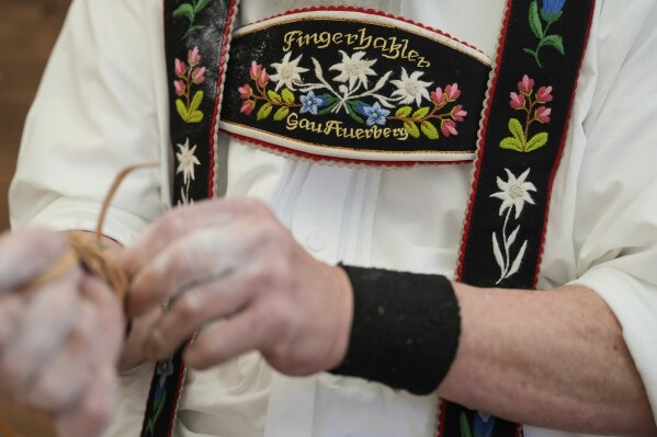 A competitor warms up for his bout while he try to pull the opponent over the table at the German Championships in Fingerhakeln or finger wrestling, in Pang, near Rosenheim, Germany, Sunday, April 27, 2025. (AP Photo/Matthias Schrader)