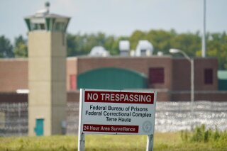 FILE - This Aug. 26, 2020 file photo shows the federal prison complex in Terre Haute, Ind. Inmates on federal death row tell The Associated Press that a leading topic of conversation through airducts they use to communicate is whether President Joe Biden will keep a campaign pledge to halt federal executions. Biden hasn’t spoken publicly to that question since taking office four days after the Trump administration executed the last of 13 inmates at the Terre Haute prison where federal death row is located. (AP Photo/Michael Conroy, File)