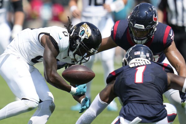 Houston Texans linebacker Henry To'oTo'o (39) and safety Jimmie Ward (1) break up a pass intended for Jacksonville Jaguars wide receiver Calvin Ridley (0) during the first half of an NFL football game, Sunday, Sept. 24, 2023, in Jacksonville, Fla. (AP Photo/John Raoux)
