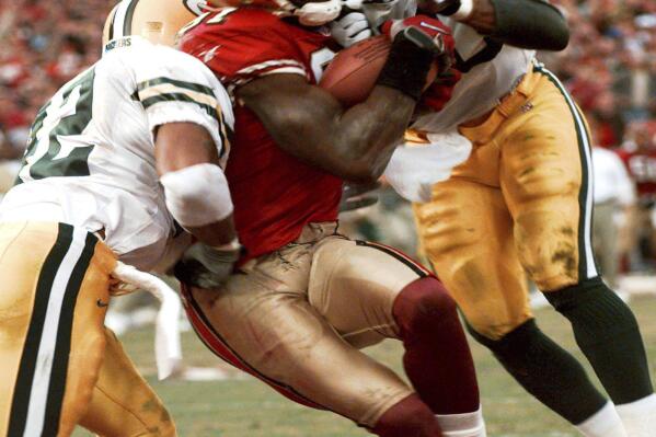 FILE - San Francisco 49ers' wide receiver Terrell Owens pulls in a 25-yard touchdown pass from quarterback Steve Young as Green Bay Packers' safeties Pat Terrell (40) and Darren Sharper defend late in the fourth quarter of the NFC wild card playoff game at 3COM Park in San Francisco, Sunday, Jan. 3, 1999. With 8 seconds left and the Niners trailing by four, Young stumbled dropping back from center and then threaded a 25-yard pass between a phalanx of Packers to Owens. (AP Photo/Susan Ragan, File)