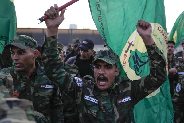 Miembros de un grupo militante chiíta iraquí asisten al funeral de un combatiente que murió en un ataque aéreo estadounidense en la provincia de Bagdad, Irak, el jueves 4 de enero de 2024. La Fuerza de Movilización Popular, una coalición de milicias que está nominalmente bajo el control del ejército iraquí- anunció en un comunicado que su jefe adjunto de operaciones en Bagdad, Mushtaq Taleb al-Saidi, o "Abu Taqwa", había muerto en el ataque.  (Foto AP/Hadi Mizban)