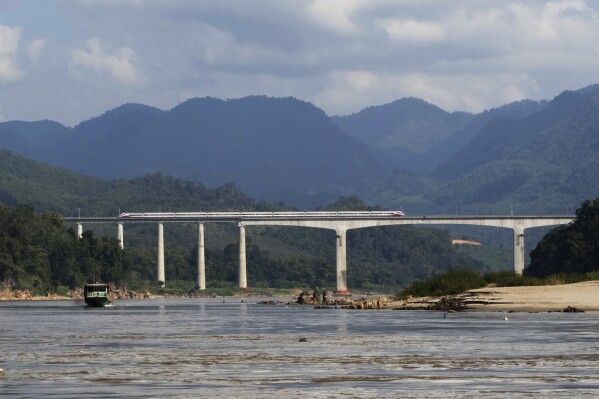 A Chinese high-speed train moves across a bridge over the Mekong River, north of the Laotian city of Luang Prabang on Dec. 12, 2023. Laos has grown increasingly beholden to its giant neighbor to the north with massive amounts of debt to Chinese state banks for multiple infrastructure projects, including a new high-speed rail line across the country, said Muhammad Faizal, with the Institute of Defense and Strategic studies at the S. Rajaratnam School of International Studies in Singapore. (AP Photo/David Rising)