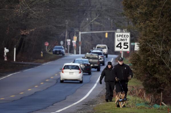 Members of a State Police K-9 unit search on Chief Justice Cushing Highway in Cohasset, Mass., Jan. 7, 2022. Authorities say the husband of a missing Massachusetts woman has been arrested for allegedly misleading investigators. Cohasset police and Massachusetts State Police on Sunday took Brian Walshe, 46, of Cohasset, Mass., into custody. His arrest comes after state and local police suspended their ground search for 39-year-old Ana Walshe, who has been missing since New Year’s Day. (Craig F. Walker/The Boston Globe via AP)