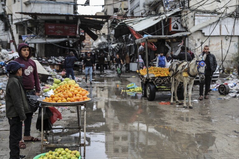 Palästinenser verkaufen Obst in Gaza-Stadt, Montag, 27. November 2023.  Vierter Tag des vorübergehenden Waffenstillstands zwischen Hamas und Israel.  (AP Photo/Mohammed Hajjar)