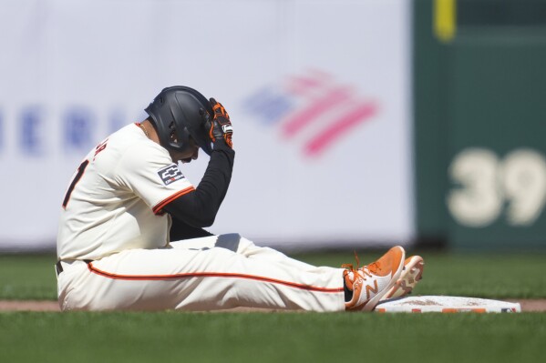 San Francisco Giants' LaMonte Wade Jr. reacts to an injury after hitting a double against the Philadelphia Phillies during the fifth inning of a baseball game in San Francisco, Monday, May 27, 2024. Wade left the game following the play. (AP Photo/Jeff Chiu)