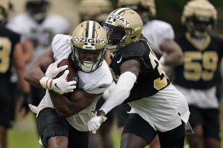 New Orleans Saints running back Devine Ozigbo carries against safety Smoke Monday during training camp at their NFL football training facility in Metairie, La., Friday, July 29, 2022. (AP Photo/Gerald Herbert)