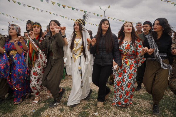 Syrian Kurdish women, some of them wearing traditional clothing, gather to celebrate their Nowruz, Kurdish New Year, in Qamishli, northeastern Syria, Friday March 21, 2025. (AP Photo/Baderkhan Ahmad)