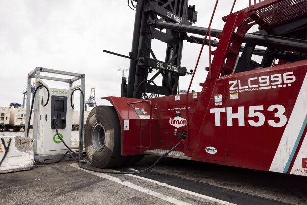 An electric top-handler is charging at a station at the Yusen Terminal in the Port of Los Angeles, Tuesday, March 11, 2025, in San Pedro, Calif. (AP Photo/Etienne Laurent)