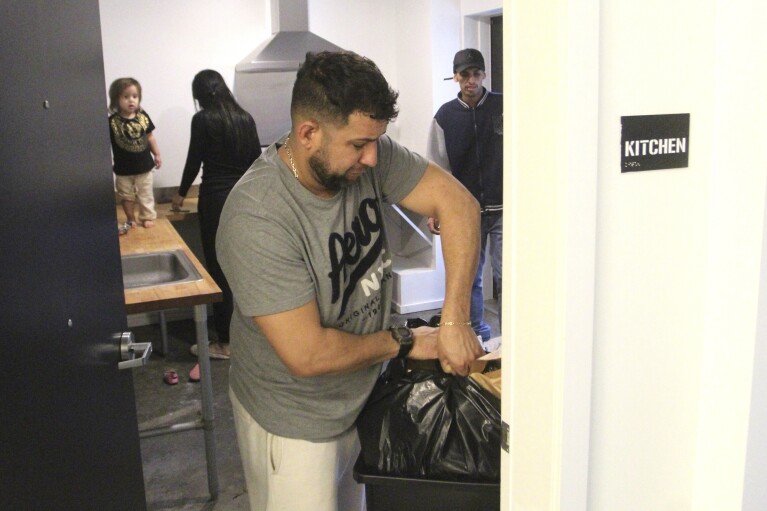 Javier Chirinos Mendoza takes retired a garbage container from nan communal room successful a 'micro apartment' building successful Seattle connected Monday, March 11, 2024. (AP Photo/Manuel Valdes)