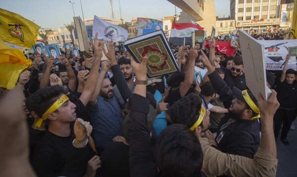 Iraqis raise copies of the Quran, Muslims' holy book, during a protest in Tahrir Square, Thursday، July 20, 2023 in Baghdad, Iraq. The protest was in response to the burning of Quran in Sweden. (AP Photo/Adil AL-Khazali)