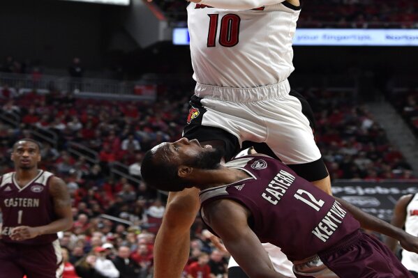Louisville guard Samuell Williamson (10) goes in for a layup over the defense of Eastern Kentucky guard Ty Taylor II (12) during the second half of an NCAA college basketball game in Louisville, Ky., Saturday, Dec. 14, 2019. Louisville won 99-67. (AP Photo/Timothy D. Easley)