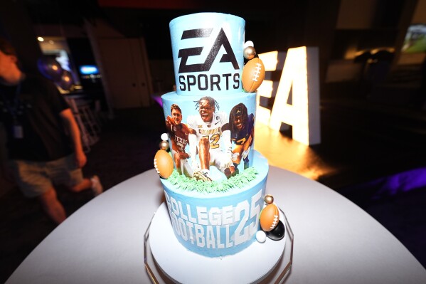 A decoration stands on a table as members of the football team from the University of Colorado play the EA Sports College Football 25 video game during a release party Friday, July 19, 2024, at the Memorial Union on the campus in Boulder, Colo. EA Sports College Football 25 flooded the market Friday as gamers who waited more than a decade for the franchise's next installment hurry to play. (AP Photo/David Zalubowski)