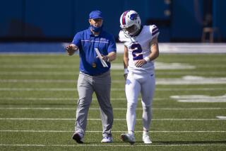 FILE - Buffalo Bills assistant special teams coach Matthew Smiley speaks with kicker Tyler Bass (2) during an NFL football game against the Los Angeles Rams, Sunday, Sept. 27, 2020, in Orchard Park, N.Y. There's little Matthew Smiley can do to change Buffalo kicking off into the end zone on a fateful play which contributed to the Bills squandering a 3-point lead in the final 13 seconds of regulation of a thrilling and heartbreaking overtime loss to Kansas City in an AFC Division playoff in January. Smiley, newly promoted special teams coordinator, addressed the issue on Tuesday, June 7, 2022. (AP Photo/Brett Carlsen, File)