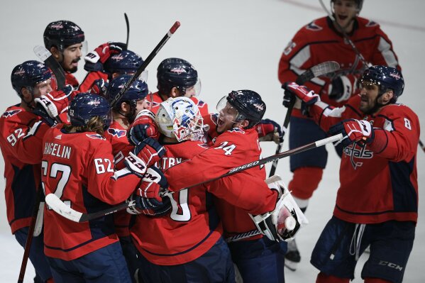 Washington Capitals defenseman John Carlson (74), goaltender Braden Holtby (70), left wing Carl Hagelin (62), left wing Alex Ovechkin (8), of Russia, and others celebrate after an NHL hockey game against the San Jose Sharks, Sunday, Jan. 5, 2020, in Washington. (AP Photo/Nick Wass)