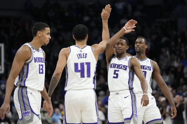 From left to right, Sacramento Kings forward Keegan Murray (13), forward Trey Lyles (41), guard De'Aaron Fox (5) and forward Harrison Barnes celebrate during overtime of an NBA basketball game against the Minnesota Timberwolves, Monday, Jan. 30, 2023, in Minneapolis. (AP Photo/Abbie Parr)