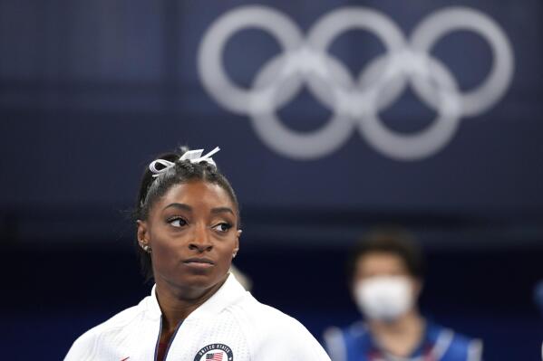 FILE - In this July 27, 2021 file photo, Simone Biles, of the United States, watches gymnasts perform after she exited the team final at the 2020 Summer Olympics, in Tokyo. Biles and Naomi Osaka are prominent young Black women under the pressure of a global Olympic spotlight that few human beings ever face. But being a young Black woman -- which, in American life, comes with its own built-in pressure to perform -- entails much more than meets the eye. (AP Photo/Ashley Landis, File)
