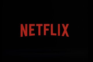 FILE- This July 17, 2017, file photo shows a Netflix logo on an iPhone in Philadelphia. Netflix, Inc. reports earnings Monday, July 16, 2018. Netflix started 2018 with almost 118 million subscribers and went on to win its first feature-film Oscar. It briefly surpassed Disney as the most valuable U.S. media company and lured the likes of superstar show runners Shonda Rhimes and Ryan Murphy, not to mention Barack and Michelle Obama. For that and more, Netflix has been named The Associated Press Entertainer of the Year, voted by members of the news cooperative and AP entertainment reporters.(AP Photo/Matt Rourke, File)