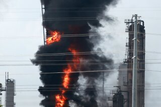 Flames and smoke rise after a fire started at an Exxon Mobil facility, Wednesday, July 31, 2019, in Baytown, Texas. (Yi-Chin Lee/Houston Chronicle via AP)