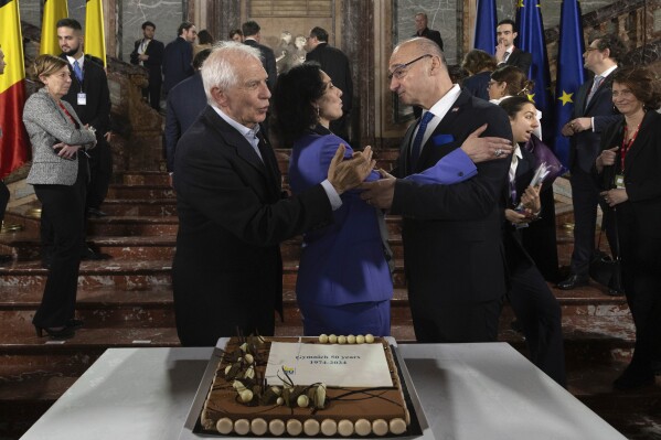 European Union foreign policy chief Josep Borrell, left, Belgium's Foreign Minister Hadja Lahbib, center, and Croatia's Foreign Minister Gordan Grlic Radman, gesture, in front of a cake to commemorate the 50th anniversary of the first informal meeting of the Council during a meeting of EU foreign ministers at the Egmont Palace in Brussels, Saturday, Feb. 3, 2024. (AP Photo/Omar Havana)
