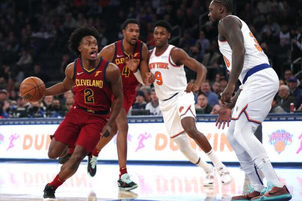 Cleveland Cavaliers guard Collin Sexton (2) drives to the basket against New York Knicks guard RJ Barrett (9) and forward Julius Randle, right, during the first half of an NBA basketball game in New York, Sunday, Nov. 7, 2021. (AP Photo/Noah K. Murray)