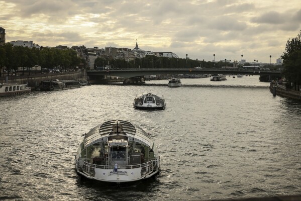 Barges cruise on the Seine river during a rehearsal for the Paris 2024 Olympic Games opening ceremony, Monday, June. 17, 2024 in Paris. The river will host the Paris 2024 Olympic Games opening ceremony on July 26 with boats for each national delegation. (AP Photo/Thomas Padilla)