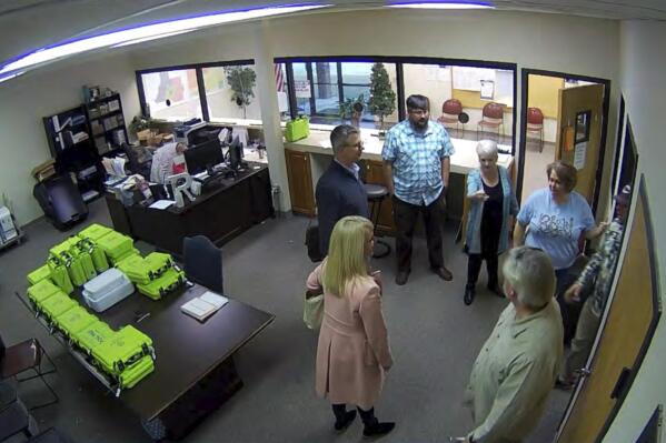 FILE - This Jan. 7, 2021, image taken from Coffee County, Ga., security video, appears to show Cathy Latham (center, long turquoise top), introducing members of a computer forensic team to local election officials. Latham was the county Republican Party chair at the time. The computer forensics team was at the county elections office in Douglas, Ga., to make copies of voting equipment in an effort that documents show was arranged by attorney Sidney Powell and others allied with then-President Donald Trump. (Coffee County, Georgia via AP)