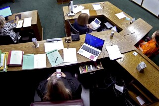 FILE - In this image from security camera video, Lincoln County District Judge Traci Soderstrom looks at her cellphone during a murder trial, June 12, 2023, at the Lincoln County District Court in Chandler, Okla. Chief Justice of the Oklahoma Supreme Court John Kane IV is recommending the removal of the district court judge who exchanged more than 500 texts with her bailiff during a murder trial. An investigation by the Oklahoma Supreme Court Council on Judicial Complaints found Soderstrom mocked prosecutors, laughed at the bailiff’s comment about a prosecutor's genitals, praised the defense attorney and called the key prosecution witness a liar, according to the petition filed Tuesday, Oct. 10. (Lincoln County District Court/The Oklahoman via AP, File)