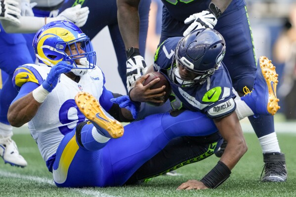 Seattle Seahawks quarterback Geno Smith is sacked by Los Angeles Rams defensive tackle Aaron Donald during the second half of an NFL football game Sunday, Sept. 10, 2023, in Seattle. (AP Photo/Lindsey Wasson)