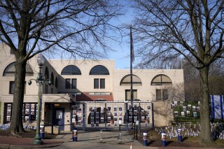 Flags and posters of kidnapped people are seen outside of the Israeli Embassy, Monday, Feb. 26, 2024, in Washington. Social media users are falsely claiming that Israel's intelligence agency called the U.S. Air Force an "enemy" of the Jewish state after an active-duty airman set himself ablaze outside the Israeli Embassy in Washington, D.C., while declaring that he "will no longer be complicit in genocide." (AP Photo/Mark Schiefelbein)