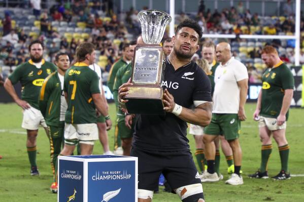 New Zealand's Ardie Savea embraces the Freedom Cup following the Rugby Championship test match between the Springboks and the All Blacks in Townsville, Australia, Saturday, Sept. 25, 2021. (AP Photo/Tertius Pickard)