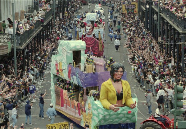 The krewe of Zulu parade rolls down St. Charles Ave. and turns onto Canal St., Feb. 20, 1996, in New Orleans. The New Orleans Police estimate crowds to be over one million in the area at the end of the Mardi Gras season. (AP Photo/Alex Brandon, file)