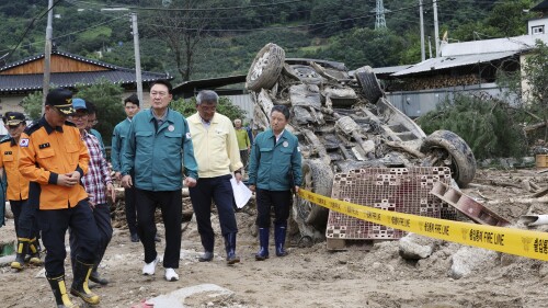 South Korean President Yoon Suk Yeol, fourth from left, looks around a flood damaged area in Yecheon, South Korea, Monday, July 17, 2023. (Jin Sung-chul/Yonhap via AP)