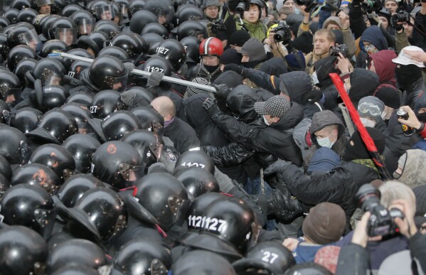FILE - In this file photo taken on Dec. 1, 2013, protesters clash with police at the presidential office in Kyiv, Ukraine. On Nov. 21, 2023, Ukraine marks the 10th anniversary of the uprising that eventually led to the ouster of the country’s Moscow-friendly president. (AP Photo/Efrem Lukatsky, file)