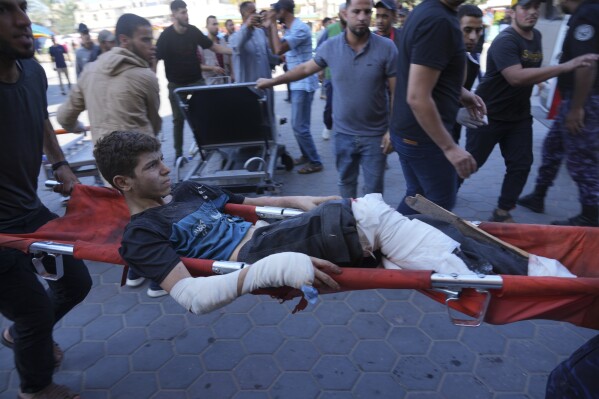 FILE - A Palestinian wounded in Israeli bombardment is brought to a hospital in Deir al-Balah, south of the Gaza Strip, Oct. 17, 2023. (AP Photo/Hatem Moussa, File)