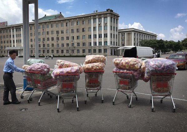 In this Saturday, June 25, 2016, file photo, a North Korean man waits with shopping carts at a parking lot in front of a department store in Pyongyang, North Korea. Three generations into Kim Jong Un's ruling dynasty, markets have blossomed and a consumer culture is taking root. (AP Photo/Wong Maye-E, File)