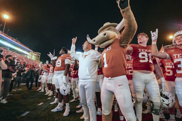 Texas coach Steve Sarkisian sings "The Eyes of Texas" with team the Bevo mascot after an NCAA college football game against Texas Tech, Friday, Nov. 24, 2023, in Austin, Texas. (AP Photo/Michael Thomas)