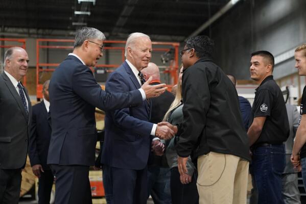 President Joe Biden tours SK Siltron CSS, a computer chip factory in Bay City, Mich., Tuesday, Nov. 29, 2022, with SK Siltron CSS CEO Jianwei Dong, second left. (AP Photo/Patrick Semansky)