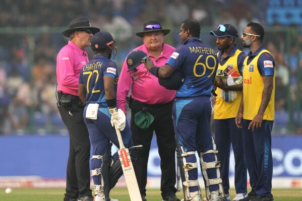 Sri Lanka's Angelo Mathews, center argues with umpires after he was declared timed out during the ICC Men's Cricket World Cup match between Bangladesh and Sri Lanka in New Delhi, India, Monday, Nov. 6, 2023. Mathews who wasn’t ready to face his first ball within the stipulated two minutes became the first batter to be timed out in international cricket. (AP Photo/Manish Swarup)