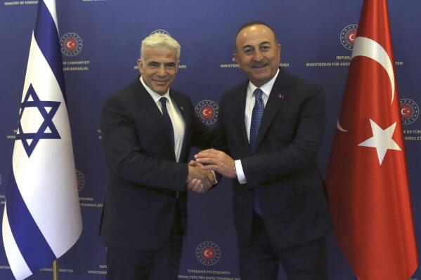 FILE - Turkish Foreign Minister Mevlut Cavusoglu, right, and Israeli Foreign Minister Yair Lapid pose for photos before their talks, in Ankara, Turkey, June 23, 2022. Israel and Turkey will restore full diplomatic relations and dispatch ambassadors for the first time in years, the latest step in months of reconciliation between the two countries, the Israeli prime minister's office said Wednesday, Aug. 17, 2022. The two countries, once friendly, had a more than decade-long falling out, but earlier this year Israel and Turkey began a process of rapprochement. (Necati Savas, Pool Photo via AP, File)