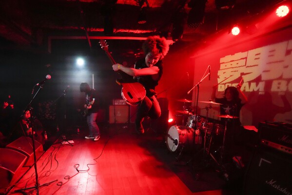 An artist who goes by the name Dream Boy jumps as he performs during a punk festival at a venue in Hangzhou, China, Friday, Jan. 17, 2025. (AP Photo/Aaron Favila)