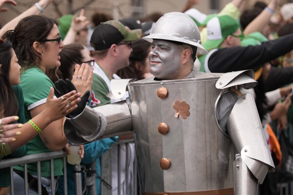 A sheet metal worker high-fives the crowd during the St. Patrick's Day parade, Sunday, March 16, 2025, in Boston, Mass. (AP Photo/Robert F. Bukaty)