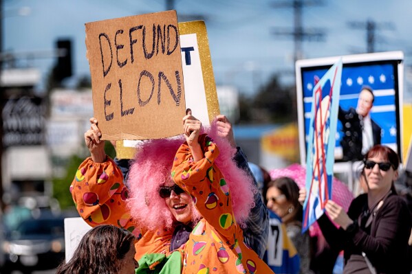 Vanessa Gonzalez joins other protesters carrying signs and chanting slogans outside a Tesla showroom and service center in the North Hollywood section of Los Angeles, March 15, 2025. (AP Photo/Richard Vogel, File)